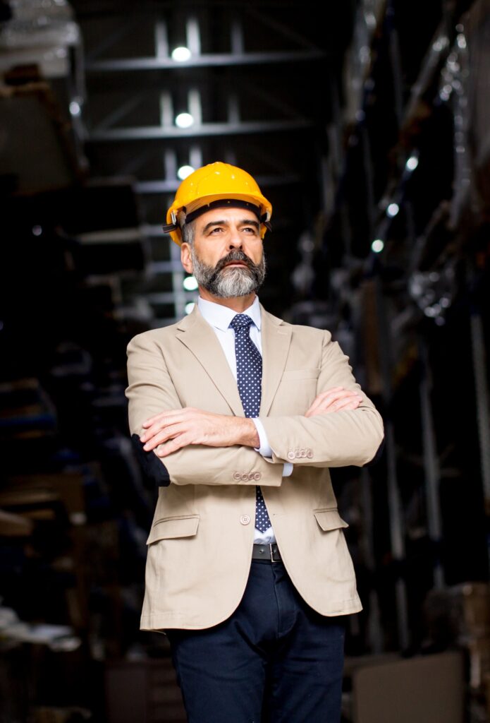 Portrait of handsome businessman withhelmet in a warehouse